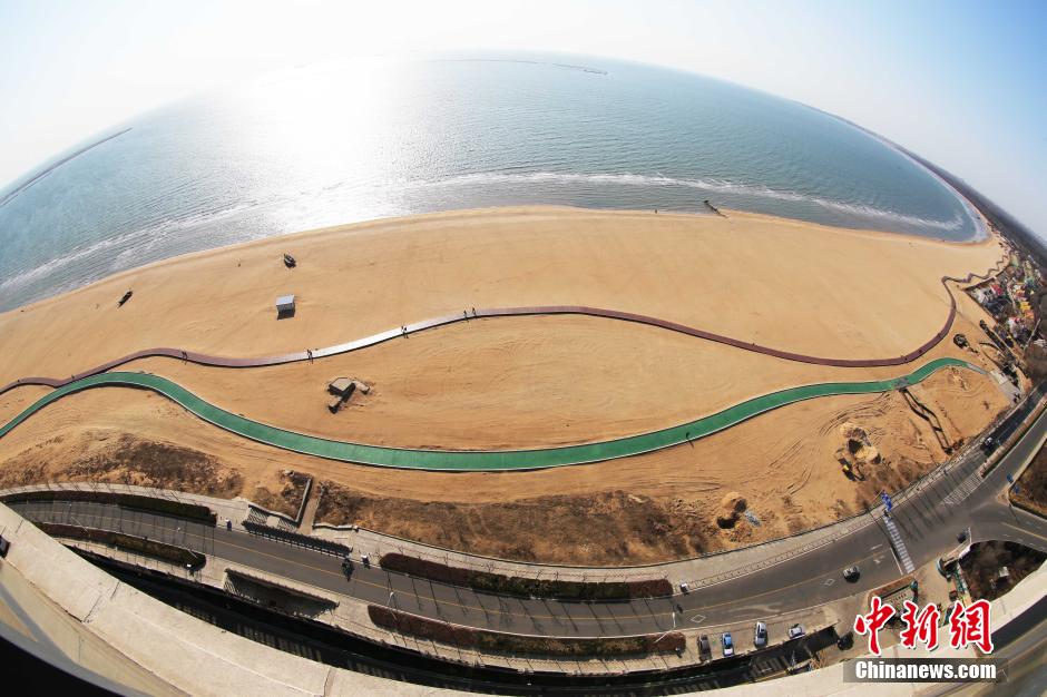 3月13日，秦皇島萬米臨海沙灘木棧道。據(jù)了解，該木棧道全長約4200米，與北戴河區(qū)原有的7500米木棧道對接后全線總長度1.17萬米，整個木棧道東起秦皇島體育基地游船碼頭，西至北戴河濕地公園，呈波浪形蜿蜒10.4公里海岸線。 中新社發(fā) 曹建雄 攝 CNSPHOTO